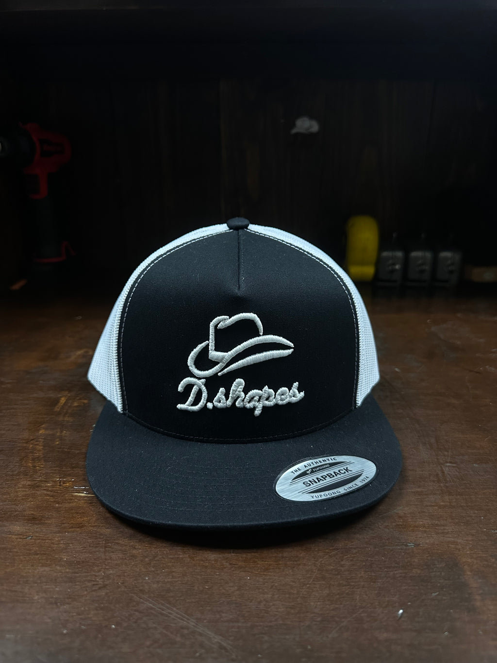 Gorra de camionero en blanco y negro con diseño de D. Shapes